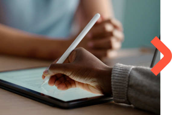 Close up of two people's hands one holding a digital pen writing on a tablet.