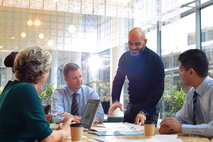 Image of a group of business people around a table.