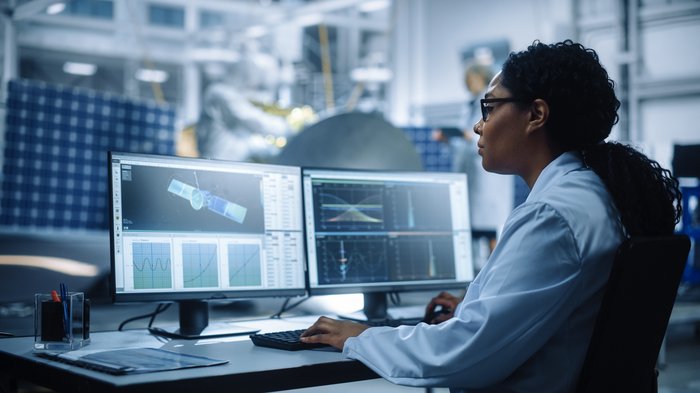 Female employee in space industry works at a computer